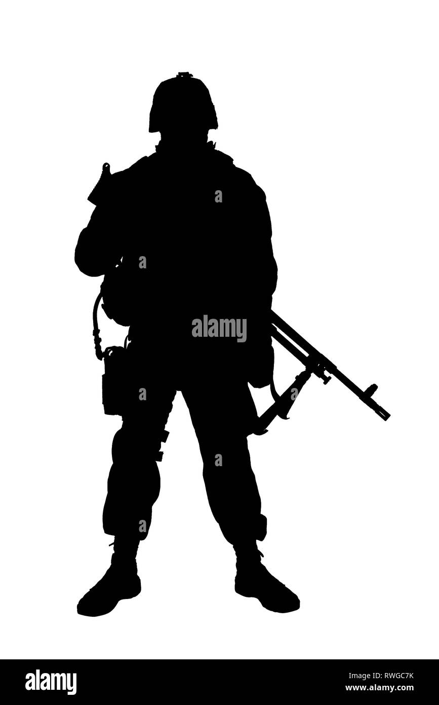 Silhouette di un soldato in camuffamento combat uniform in piedi con la mitragliatrice. Foto Stock