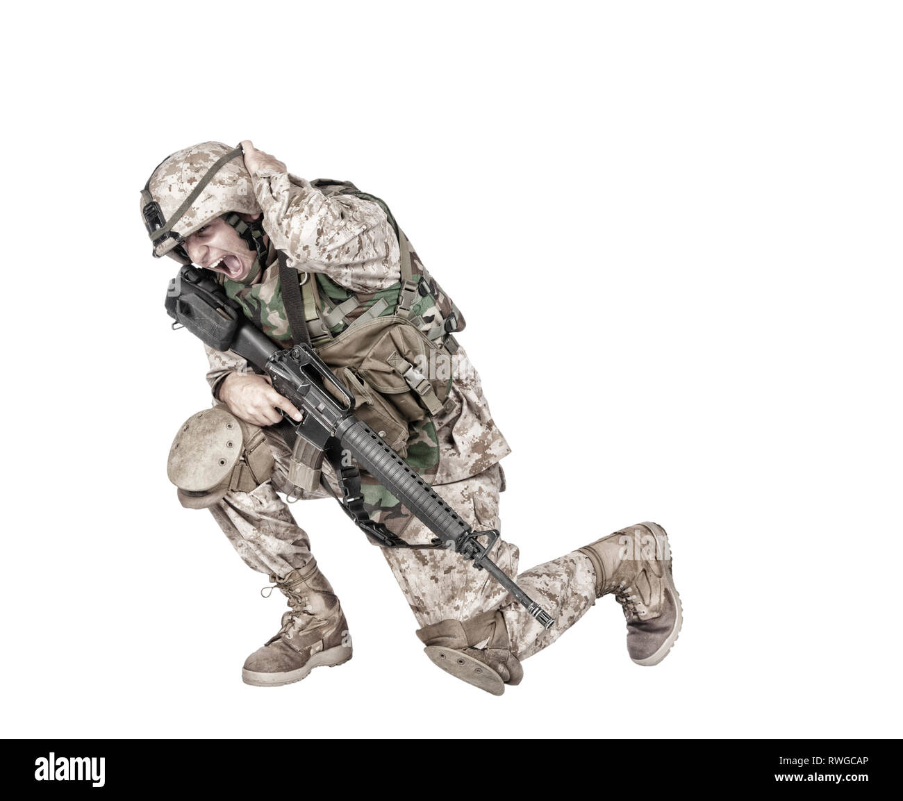 Soldato accovacciato a terra che copre le loro orecchie dopo un incendio nel foro di avvertimento. Foto Stock