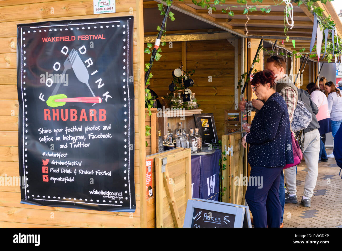 People shopping a occupato Wakefield cibo, drink & Rabarbaro Festival 2019 Visita il commercio di mercato bancarella vendendo bottiglie di gin - West Yorkshire, Inghilterra, Regno Unito Foto Stock