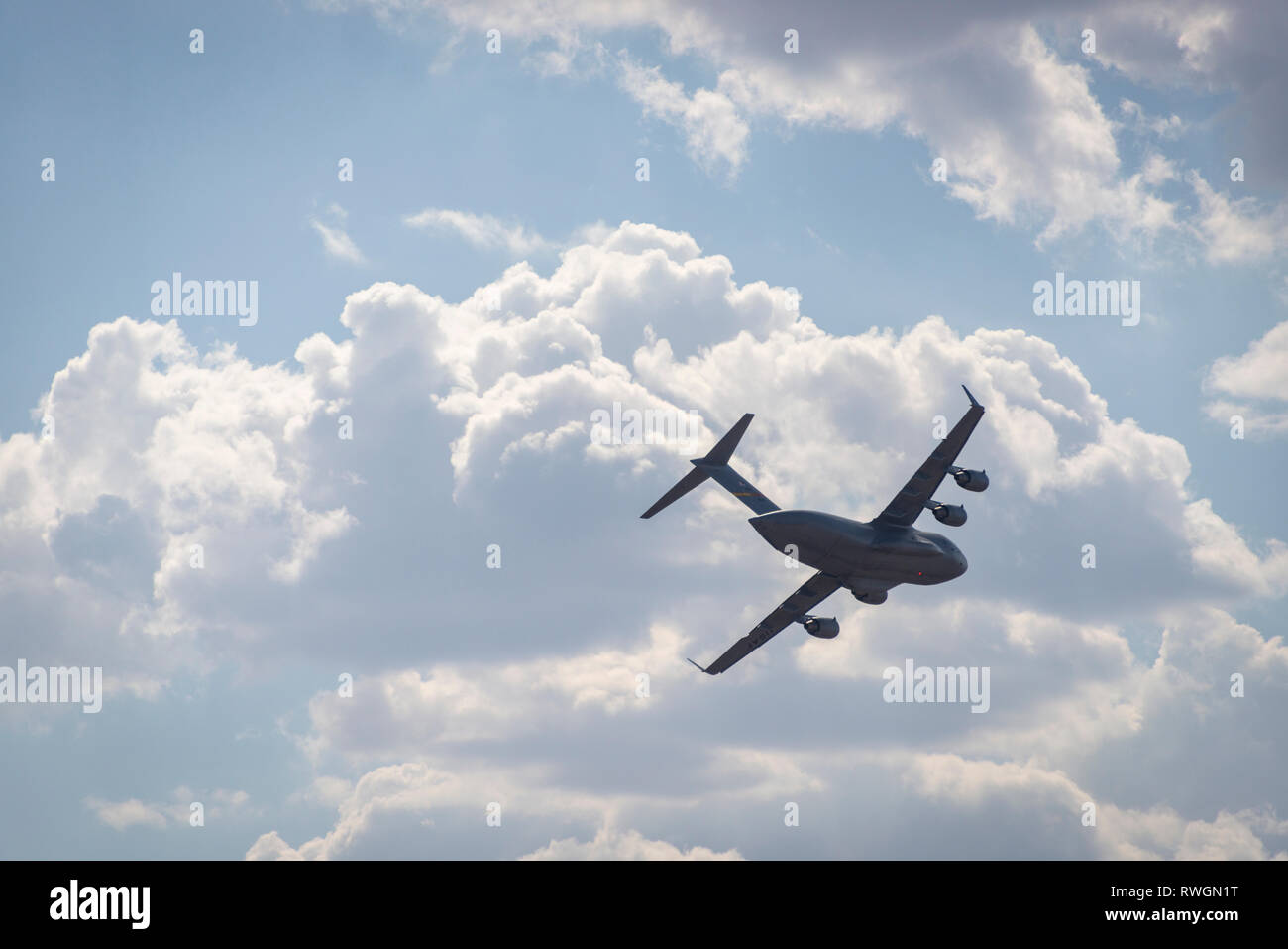 Un Boeing C-17 Globemaster III in volo, bancario contro un cielo nuvoloso Foto Stock