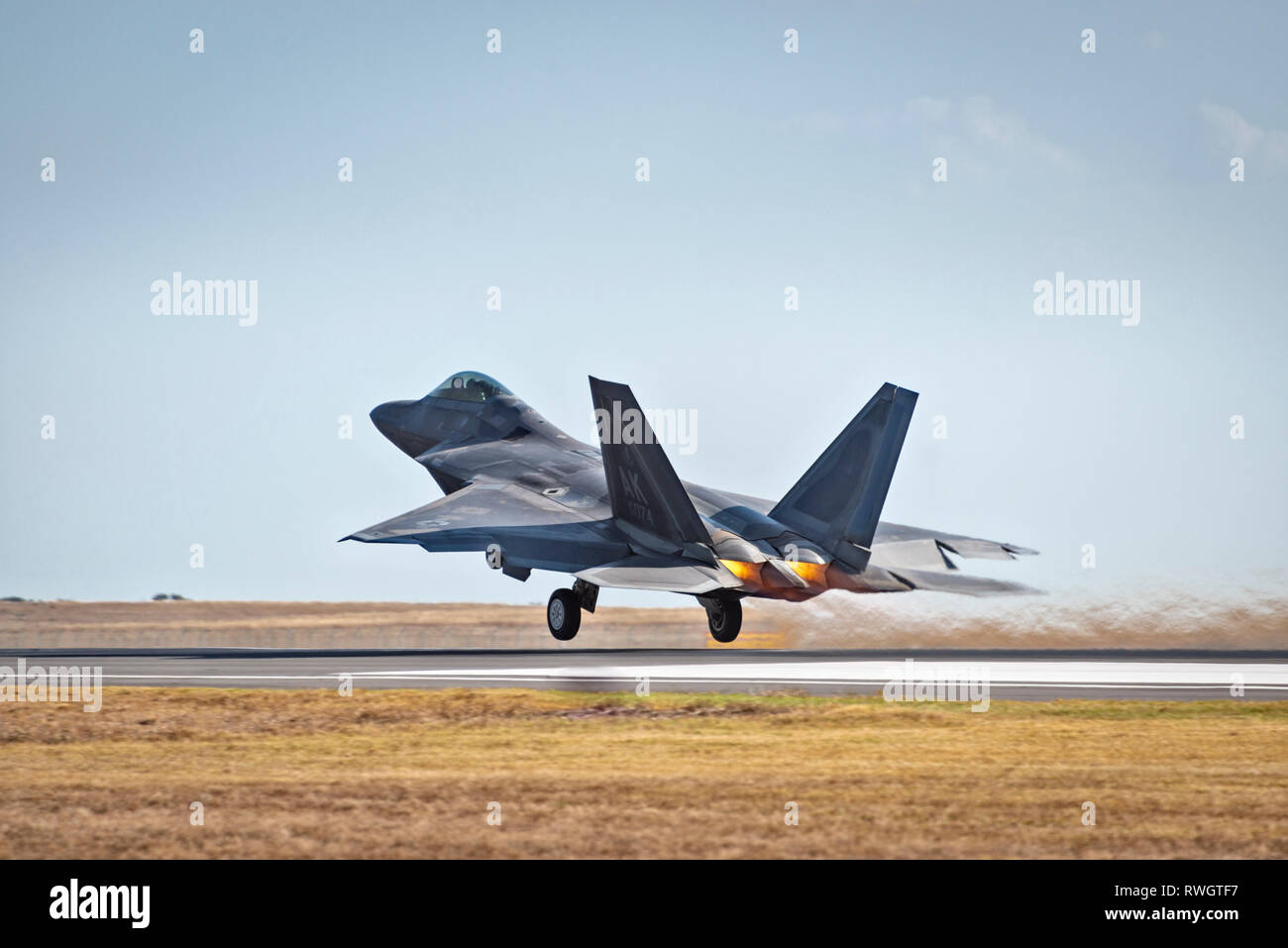 US Air Force F-22 Raptor in volo,prendendo il largo con fiamme da motori, atterraggio visibile Foto Stock