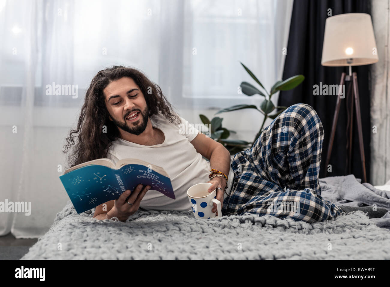 Positivo gioioso uomo disteso con una tazza di caffè Foto Stock