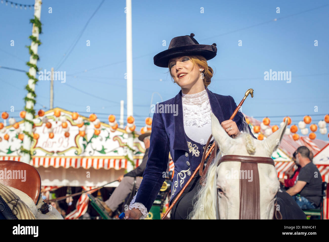 Giovane e bella donna attraente cavalcare cavalli andalusi (puro Cavallo Spagnolo) celebra il Siviglia fiera di aprile Foto Stock