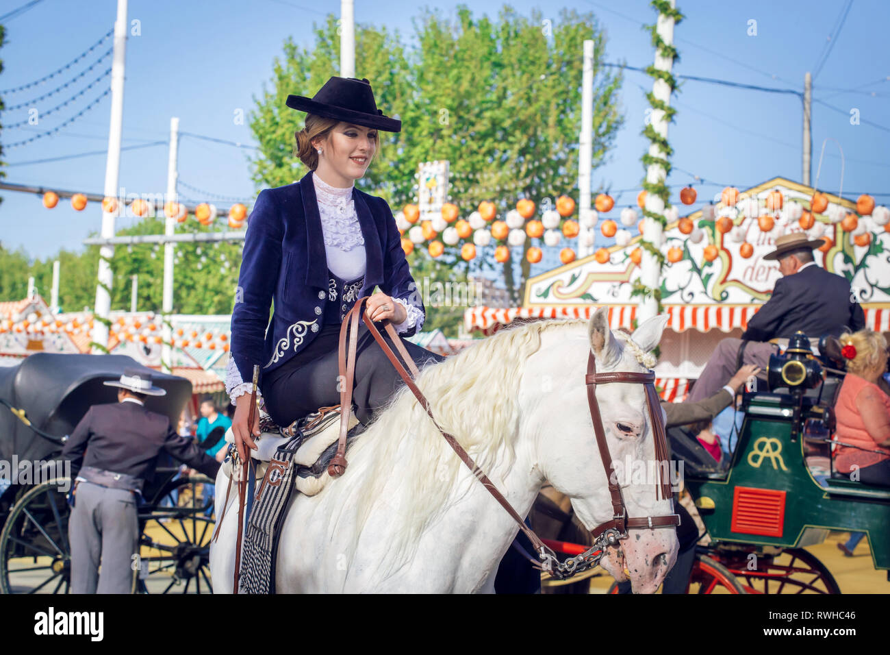 Giovane e bella donna attraente cavalcare cavalli andalusi (puro Cavallo Spagnolo) celebra il Siviglia fiera di aprile Foto Stock