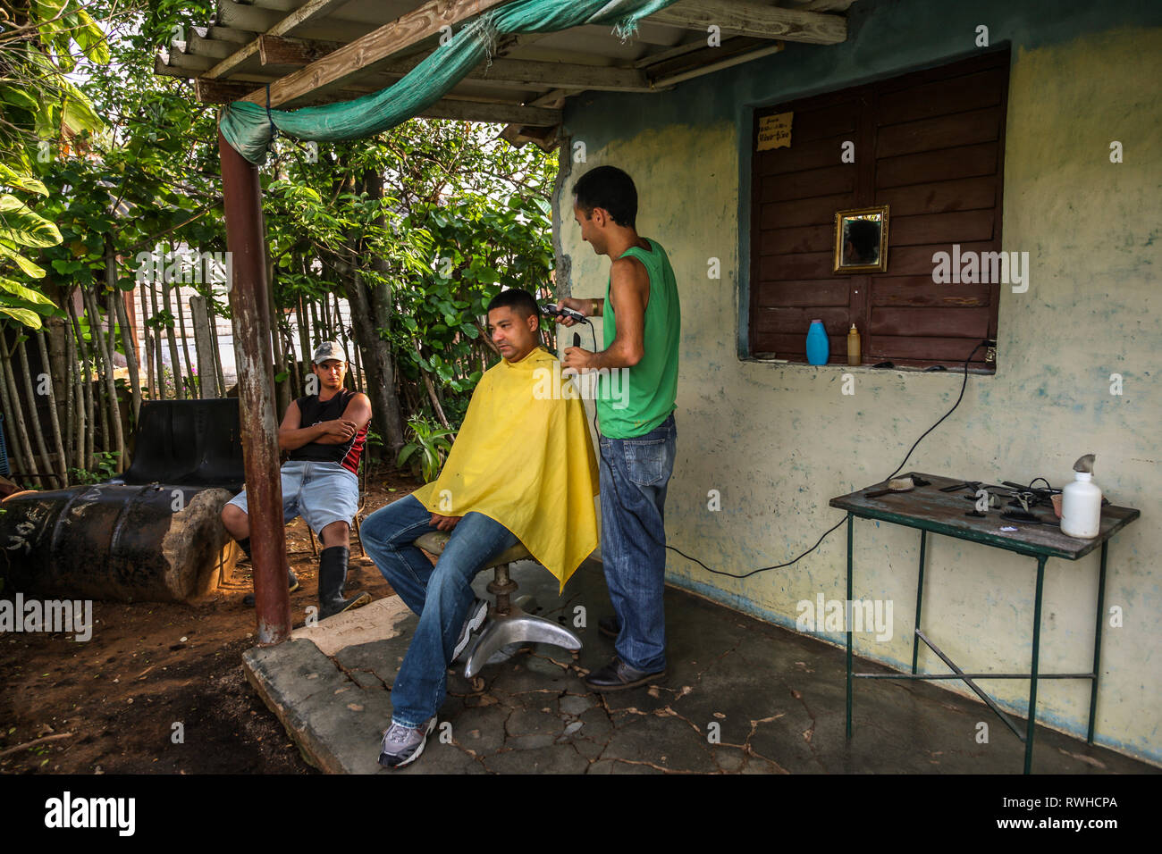 Artemisa, Cuba. 29 Maggio, 2009. Lavoratore agricolo si ottiene un taglio di capelli in un barbiere rurali al di fuori Artemisa, Cuba. Foto Stock