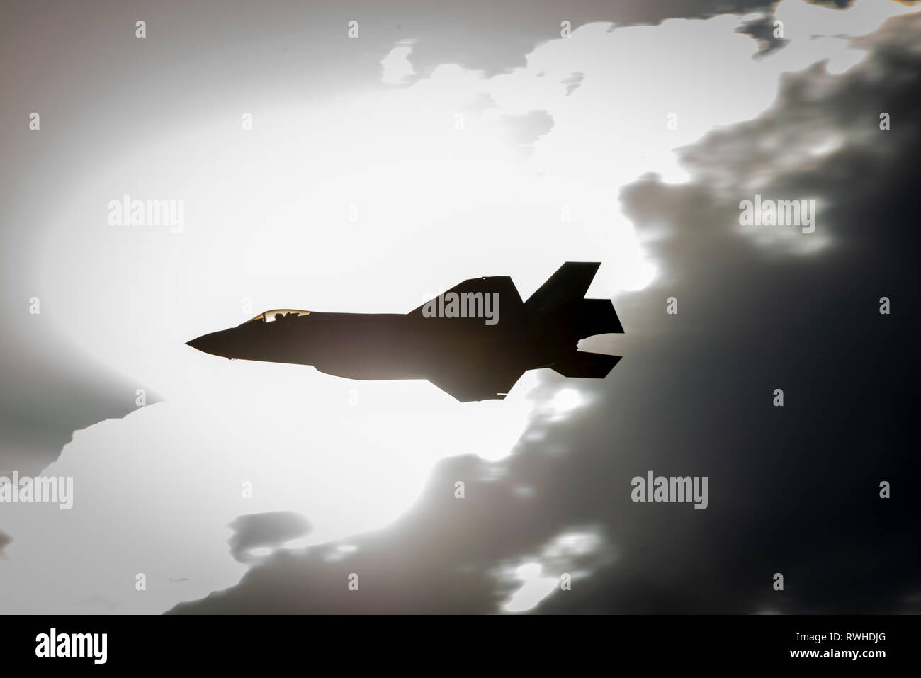 Lockheed Martin F-35 Lightning II in silhouette contro una soffiata fuori sky, abstract Foto Stock