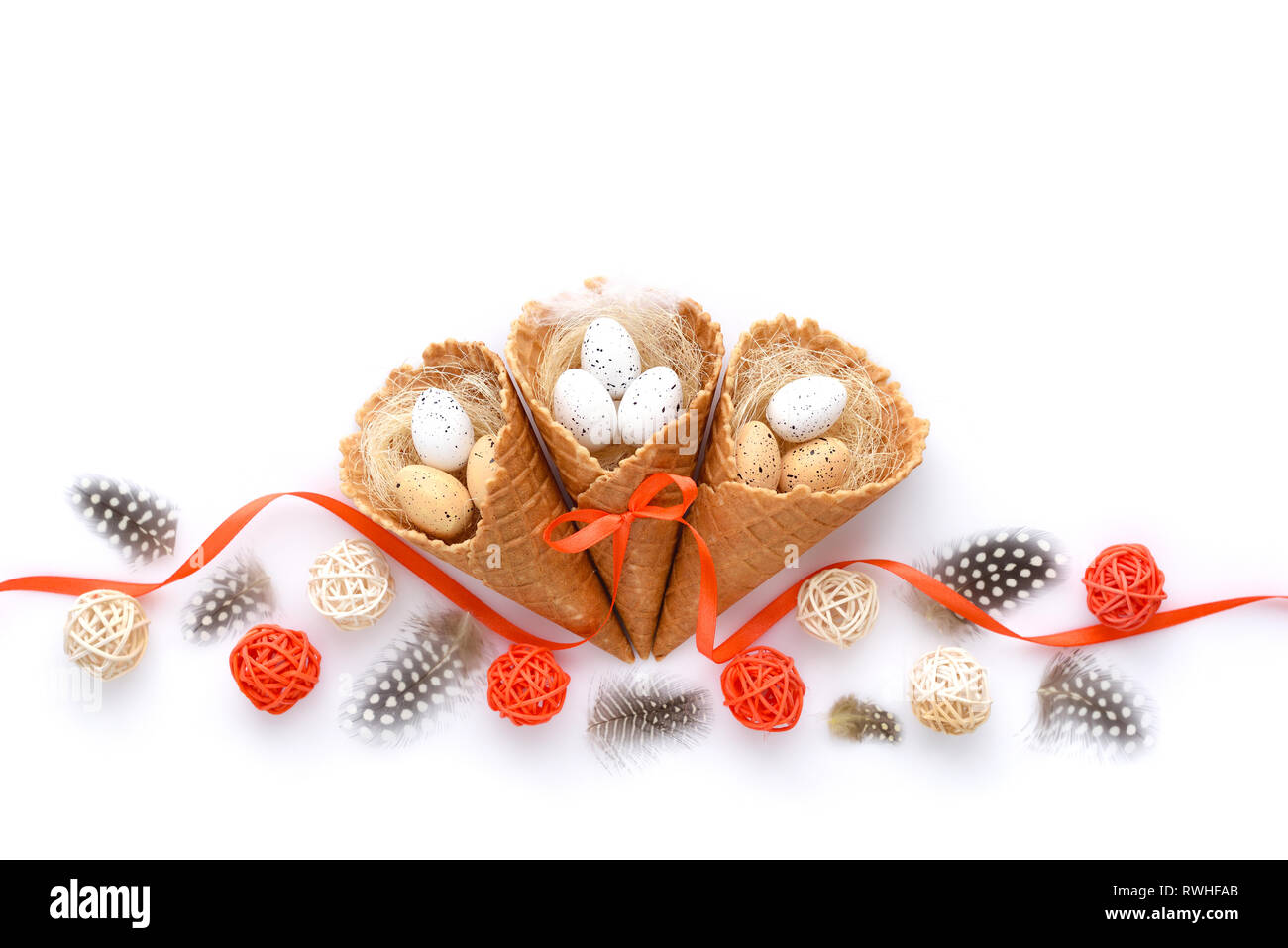 Festa di Pasqua sfondo con waffle coni con piccole uova su sfondo bianco. Vista dall'alto. Foto Stock