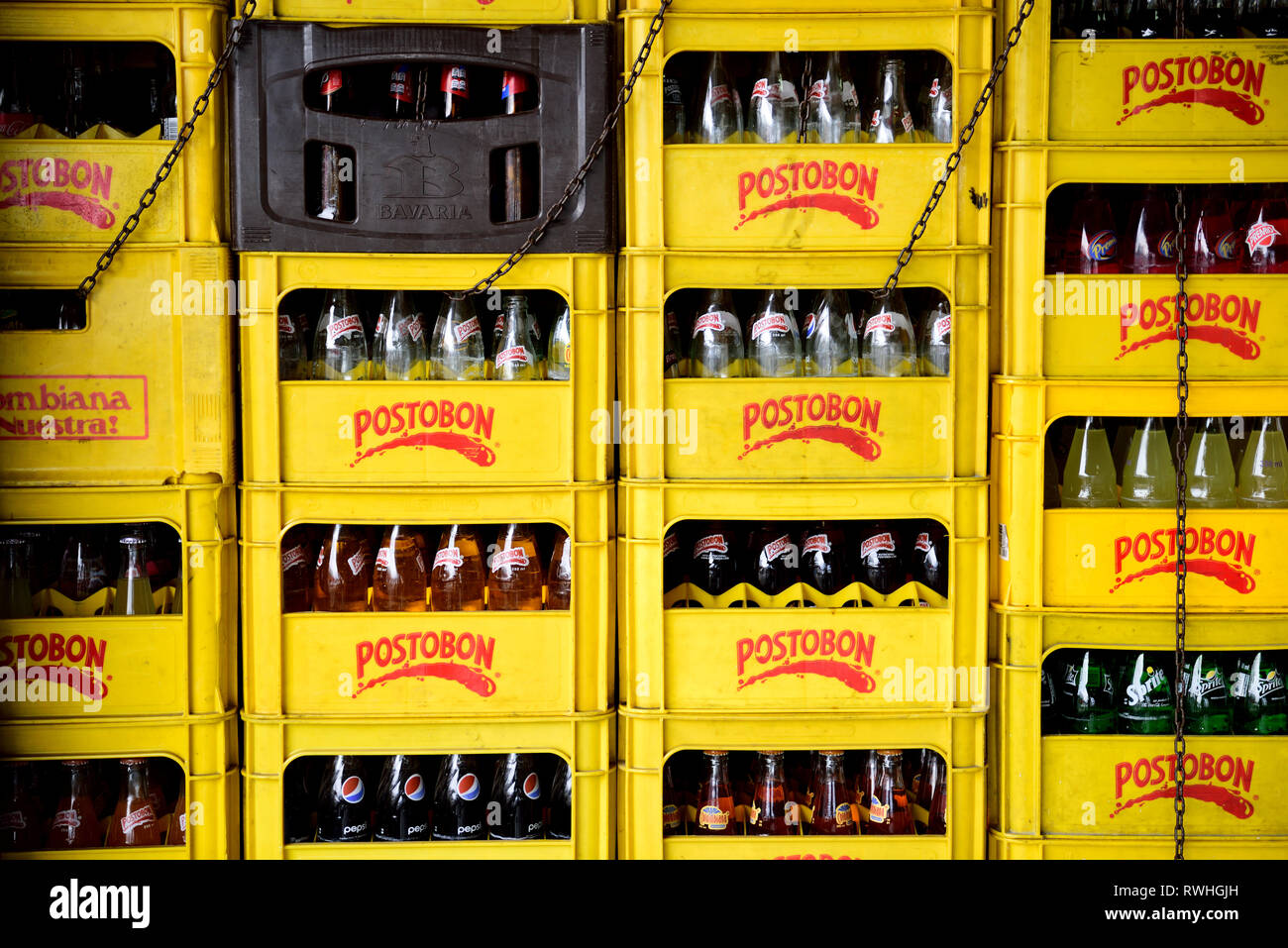 Righe e pile di giallo Postobon casse e bottiglie in Colombia, Sud America. Foto Stock