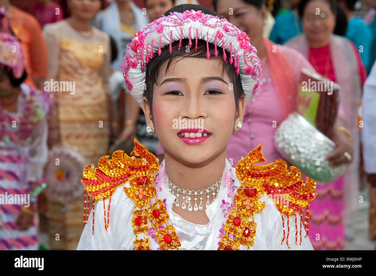 Ritratto di un giovane ragazzo birmano vestito in costume buddista e volto fatto con trucco assiste alla sua cerimonia di arrivo di età in Myanmar Mandalay Foto Stock