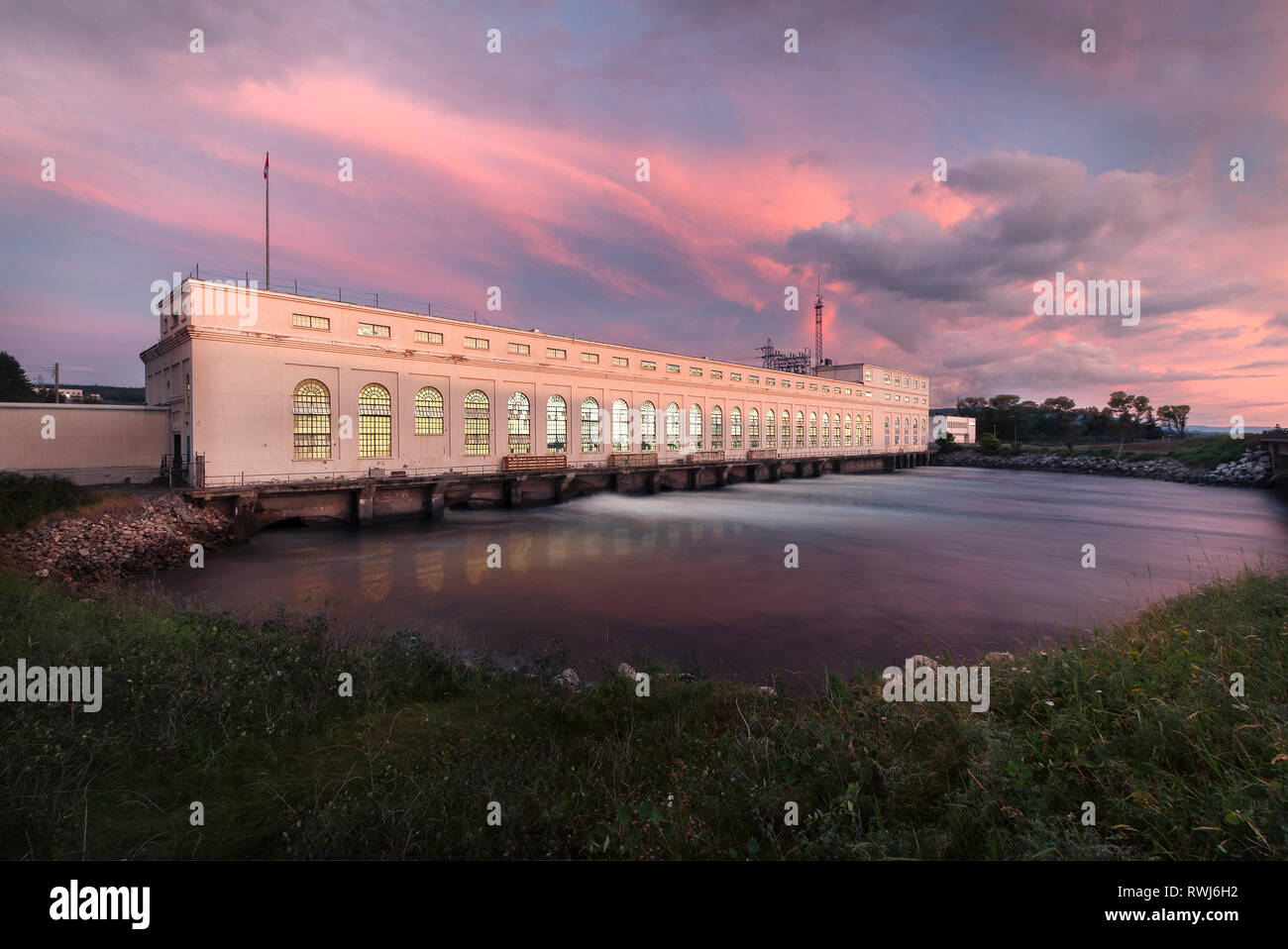 Sera riflessi del tramonto, le luci si accendono a Deer Lake Power House Building, Deer Lake, Terranova e Labrador Foto Stock