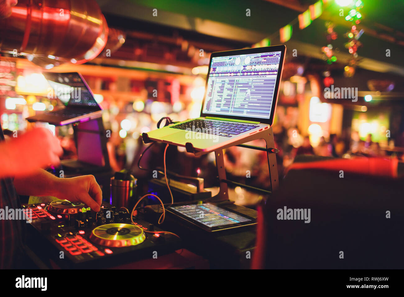 Le mani di DJ mix di tracce sul giradischi digitale e software sul computer portatile con il software di mixaggio professionale.disc jockey riprodurre musica spettacolo Foto Stock