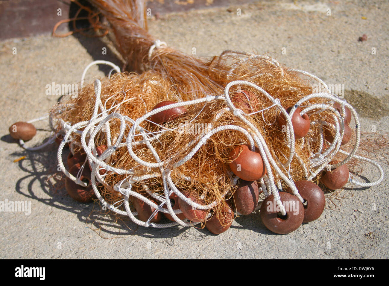 Vecchia rete da pesca con corde e galleggia sulla spiaggia Foto Stock