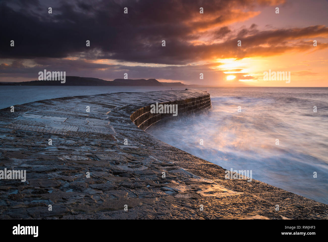 Lyme Regis, Dorset, Regno Unito. Il 7 marzo 2019. Regno Unito Meteo. Nuvole edificio all'alba sopra il porto di Cobb muro a Lyme Regis nel Dorset prima di una banda di acquazzone è venuto a. Credito Foto: Graham Hunt/Alamy Live News Foto Stock