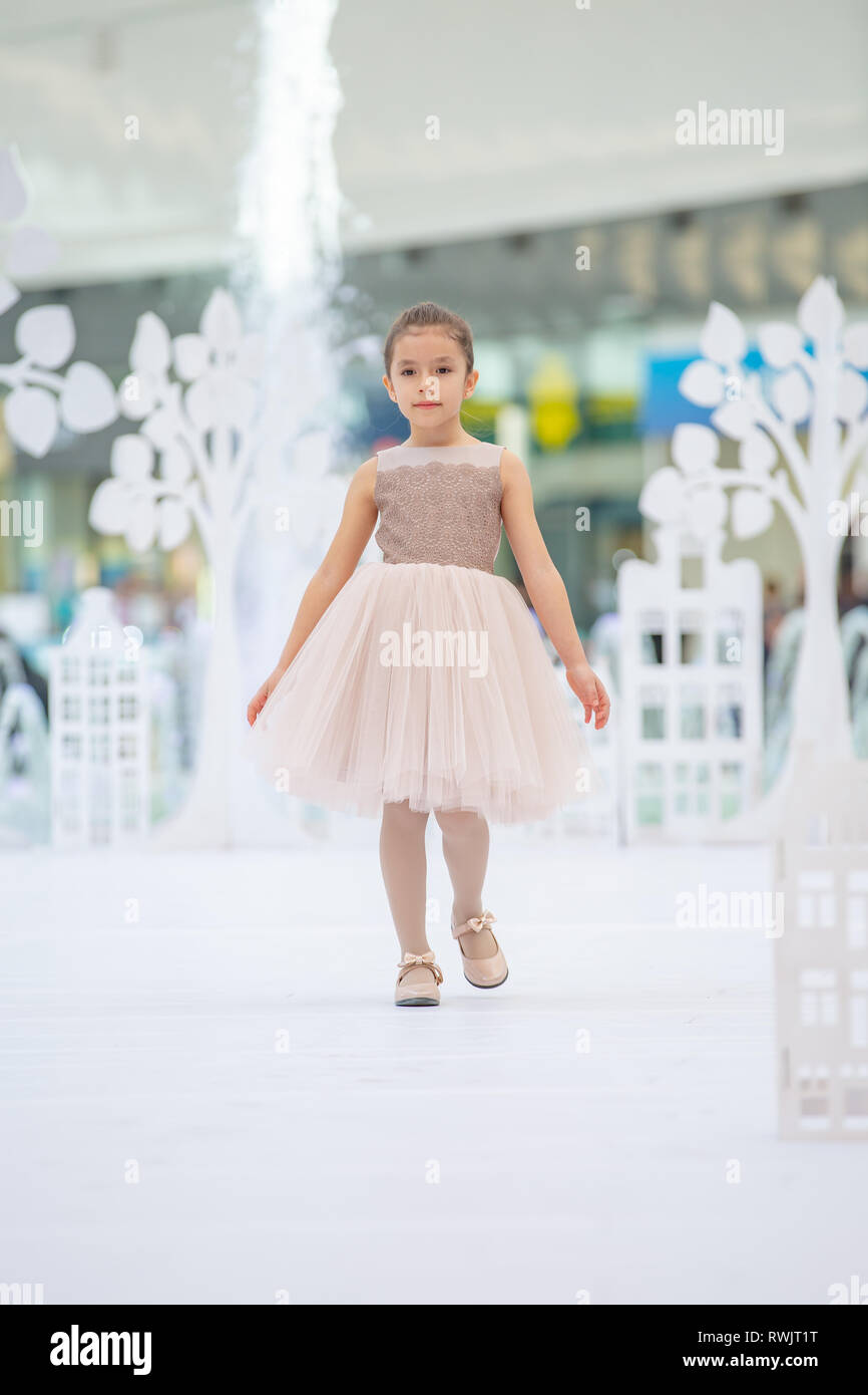 Kiev Ucraina nel marzo 03.2019. UKFW. Ukrainian Moda per bambini al giorno. Bambina modello usurata in abito color pastello che pongono a podio al fashion show Foto Stock