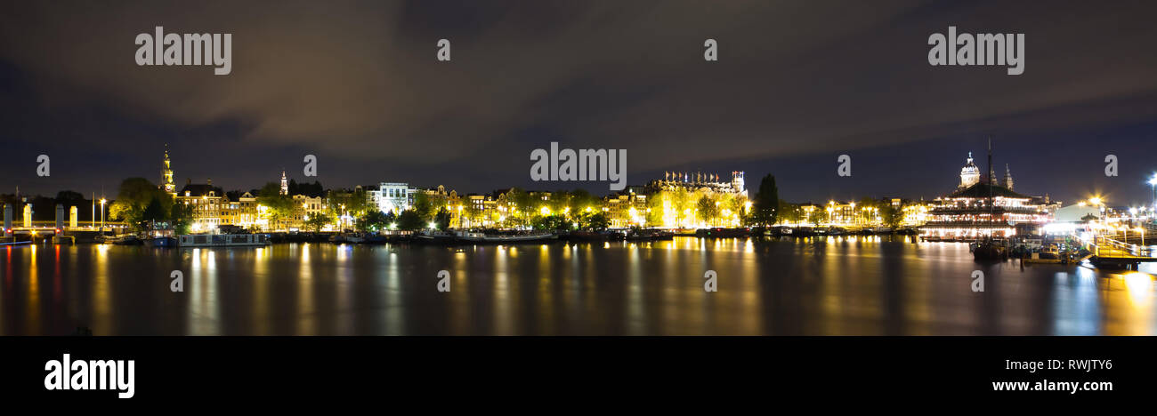 Amsterdam panorama notturno - Vista sul mare Palace, la chiesa di San Nicola e Grand Hotel Amrath - Esposizione lunga Foto Stock