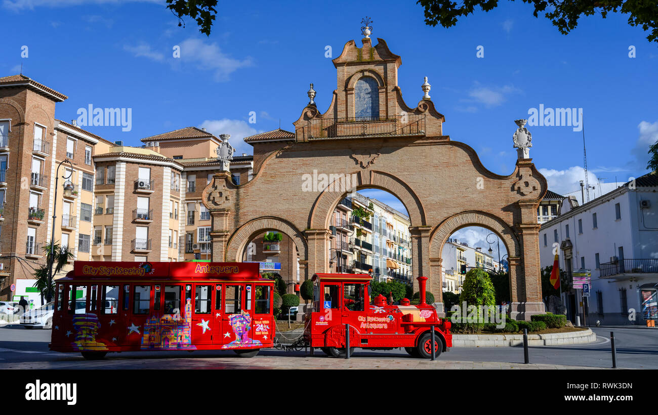 Rosso brillante passeggeri del veicolo come un tour treno su una strada in una città spagnola; Antequera, Malaga, Spagna Foto Stock