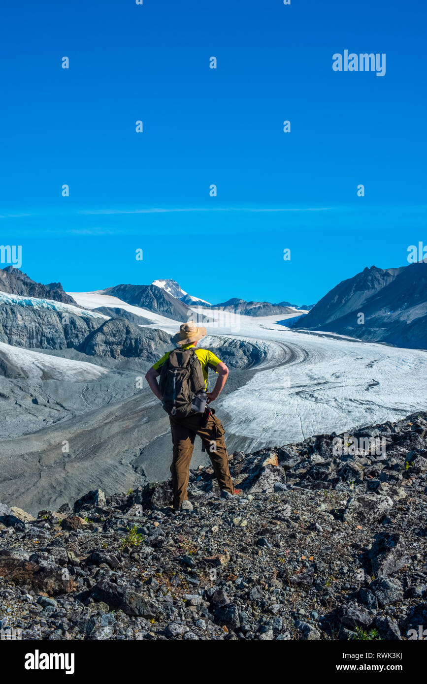 Un uomo cammina nel ghiacciaio Gulkana valle nella parte orientale di Alaska Range nel centro-sud della Alaska in un assolato pomeriggio di estate Foto Stock