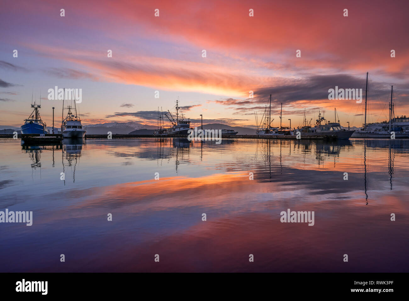 Commerciale barche da pesca in Auke Bay al tramonto, Alaska sudorientale; Juneau, Alaska, Stati Uniti d'America Foto Stock