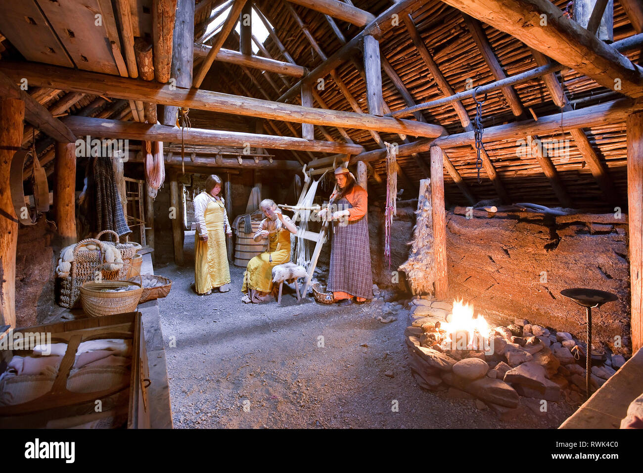 Parks Canada intepreters in costume di eseguire compiti tradizionali all'interno di un ricreato Viking longhouse presso l'Anse aux Meadows National Historic Site, l'Anse aux Meadows, Terranova, Canada Foto Stock