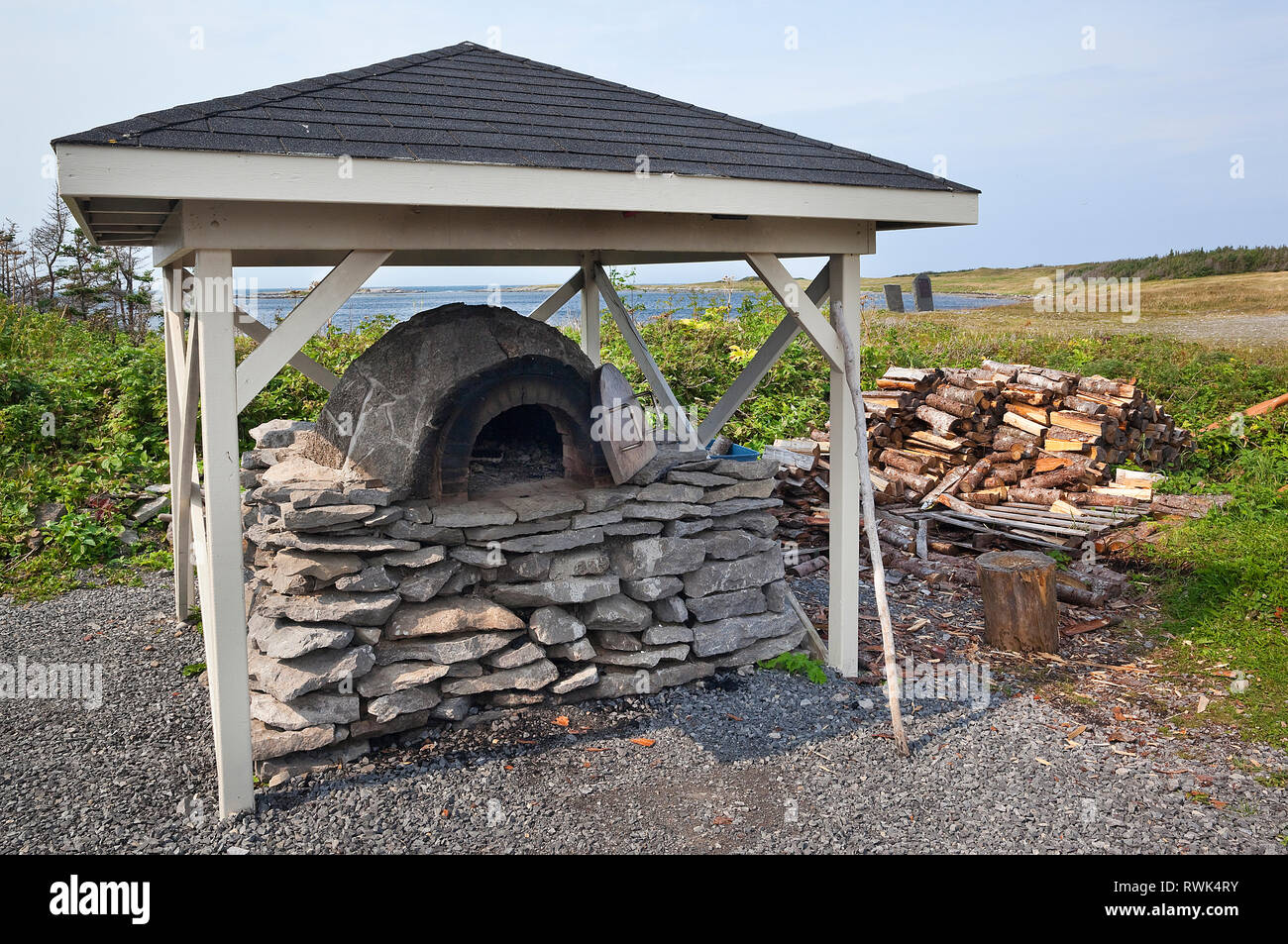 All'aperto, a legna, mattone-e-pietra forno pane su un basamento in pietra. Il forno è utilizzato da Parks Canada interpreti per dimostrare la tradizionale pane-tecniche di cottura durante gli eventi di degustazione tenutasi a Port au choix National Historic Site, Port au choix, Terranova, Canada Foto Stock