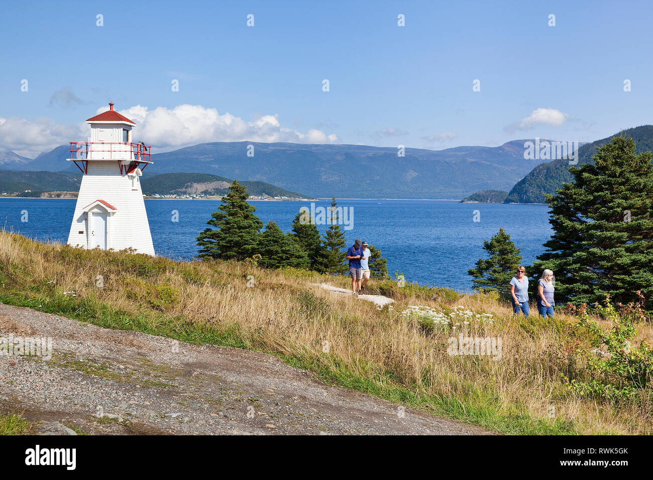 I visitatori per motivi di Woody Point Lighthouse che sorge nella parte superiore del braccio di Bonne Bay e il bordo settentrionale della città di Woody Point, Parco Nazionale Gros Morne, Terranova, Canada Foto Stock