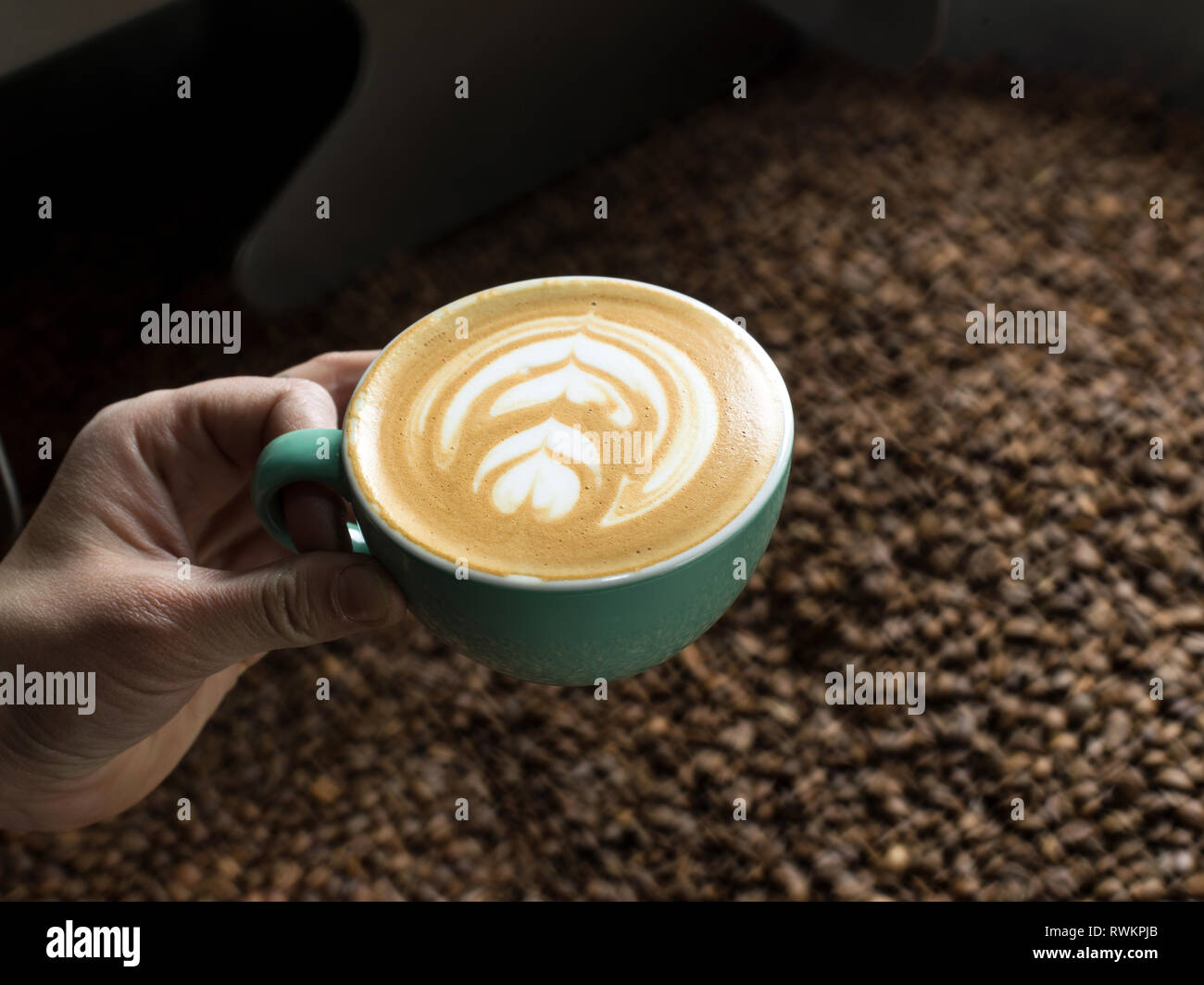 Mano azienda tazza di caffè in un caffè di torrefazione Foto Stock