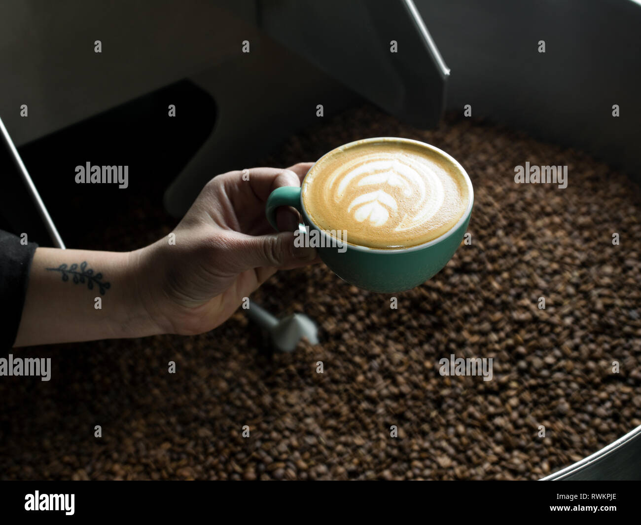 Mano azienda tazza di caffè in un caffè di torrefazione Foto Stock