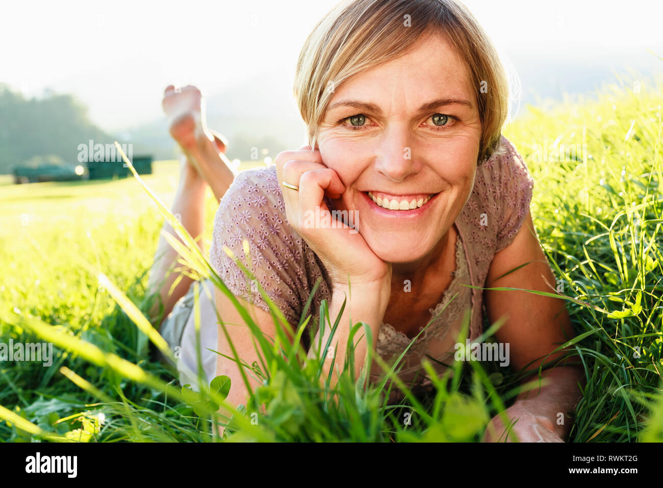 Donna sdraiata su erba in campagna Foto Stock