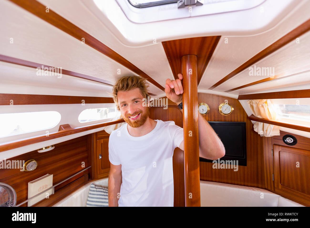 Giovane uomo in barca a vela cabin, ritratto Foto Stock