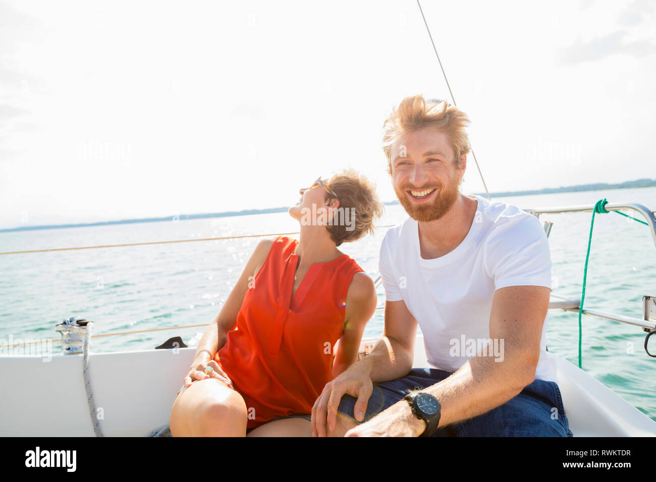 Giovane uomo e donna matura la vela sul lago Chiemsee, Baviera, Germania Foto Stock