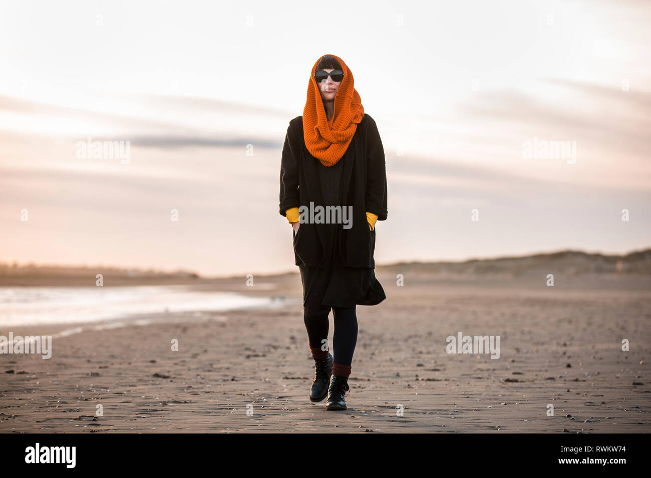 Donna che cammina da solo sulla spiaggia Foto Stock