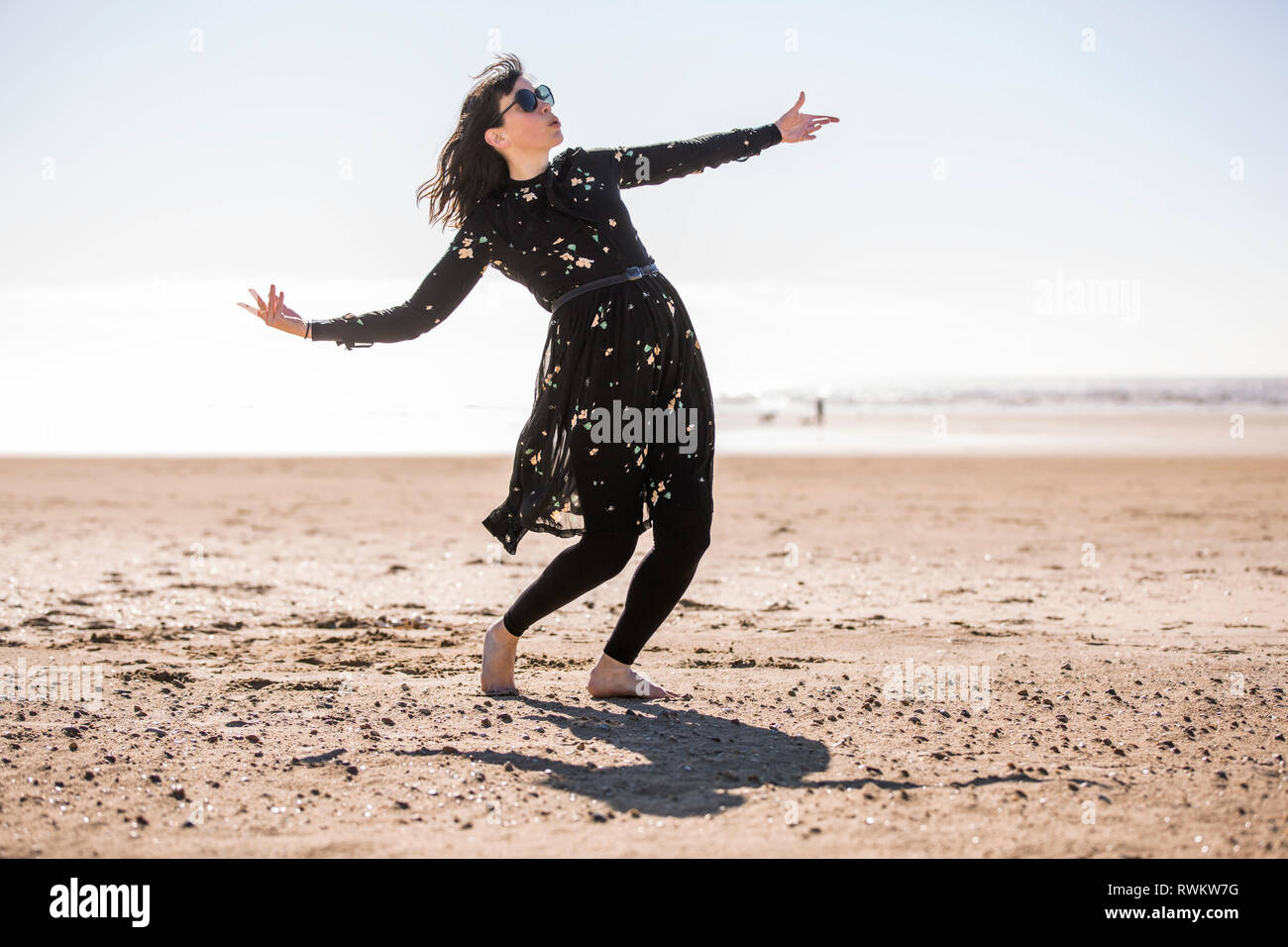 Woman Dancing sulla spiaggia Foto Stock