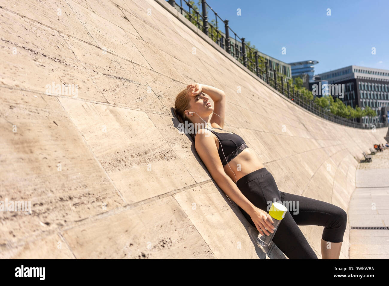 Giovane donna prendendo break da esercitare nella città di Berlino, Germania Foto Stock