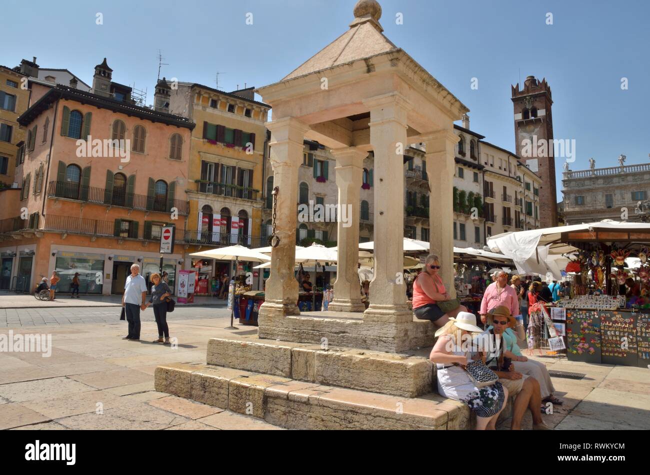 Verona, Italia - 6 Agosto 2014: persone sitted presso la guglia storico situato in Piazza delle Erbe (piazza del Mercato) a Verona, Italia settentrionale. Foto Stock