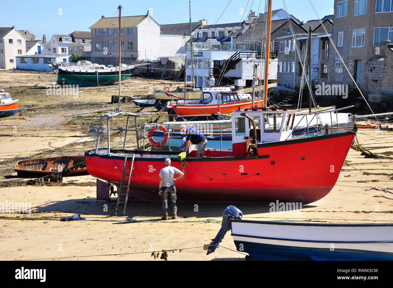 I pescatori che lavorano sulle loro barche sulla spiaggia di Hugh Town, St Mary, Isole Scilly. Foto Stock