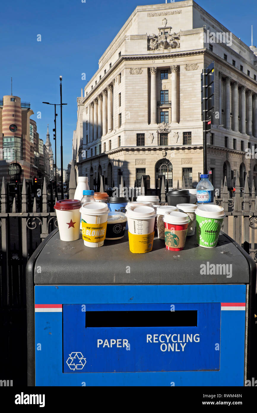 Carta e plastica vuota bicchieri e bottiglie di plastica in piedi su un riciclaggio della carta solo il bidone dei rifiuti stazione della metropolitana di Bank nella città di Londra UK KATHY DEWITT Foto Stock