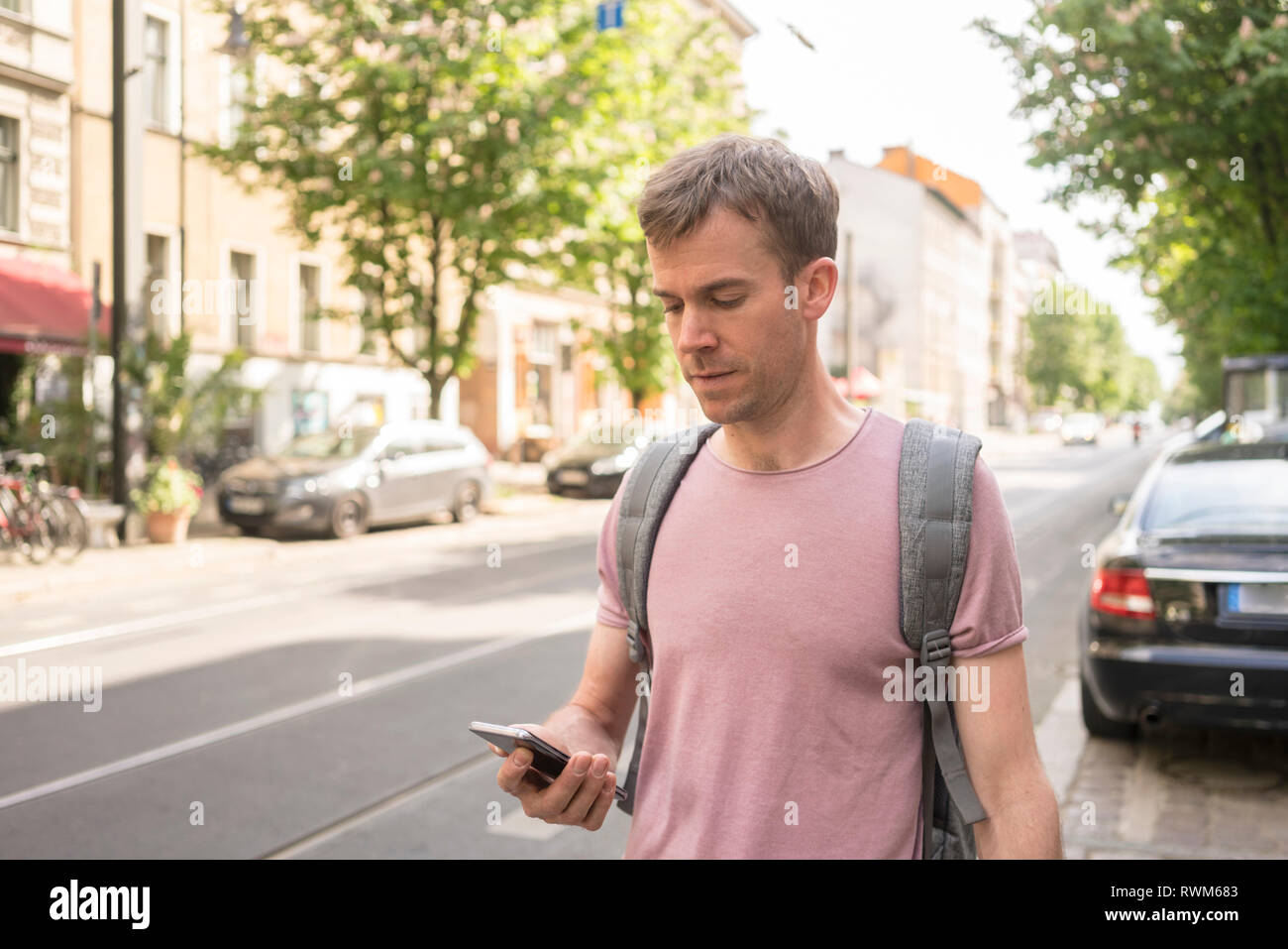 Maschio imprenditore freelancer utilizzando il suo telefono cellulare, Berlino, Germania Foto Stock