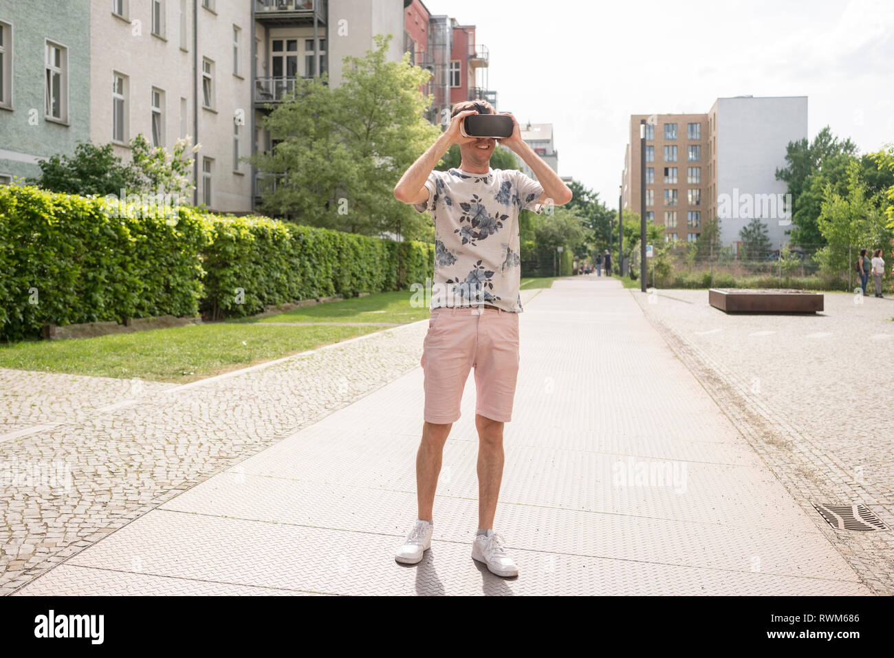 Uomo con la realtà virtuale gli occhiali di protezione in ambiente urbano di Berlino, Germania Foto Stock