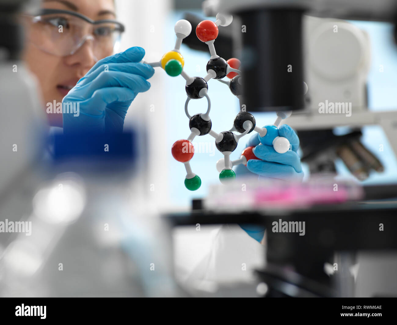 Scienziato progettazione di farmaco formula usando la sfera e stick modello molecolare in laboratorio Foto Stock