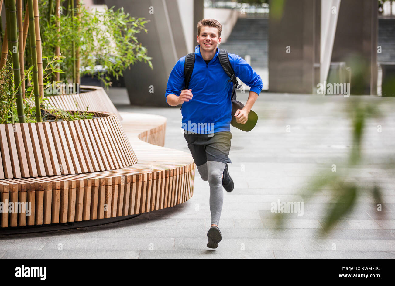 Giovani runner jogging in city square, London, Regno Unito Foto Stock