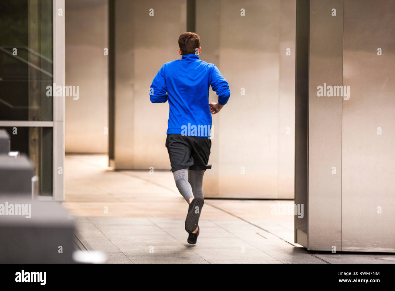 Giovani runner jogging sul marciapiede, London, Regno Unito Foto Stock