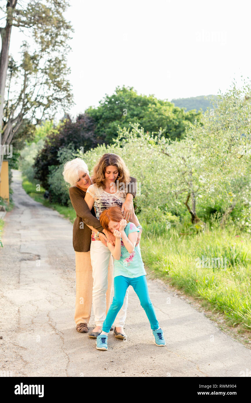 Ragazza sulla strada rurale con la madre e nonna Foto Stock