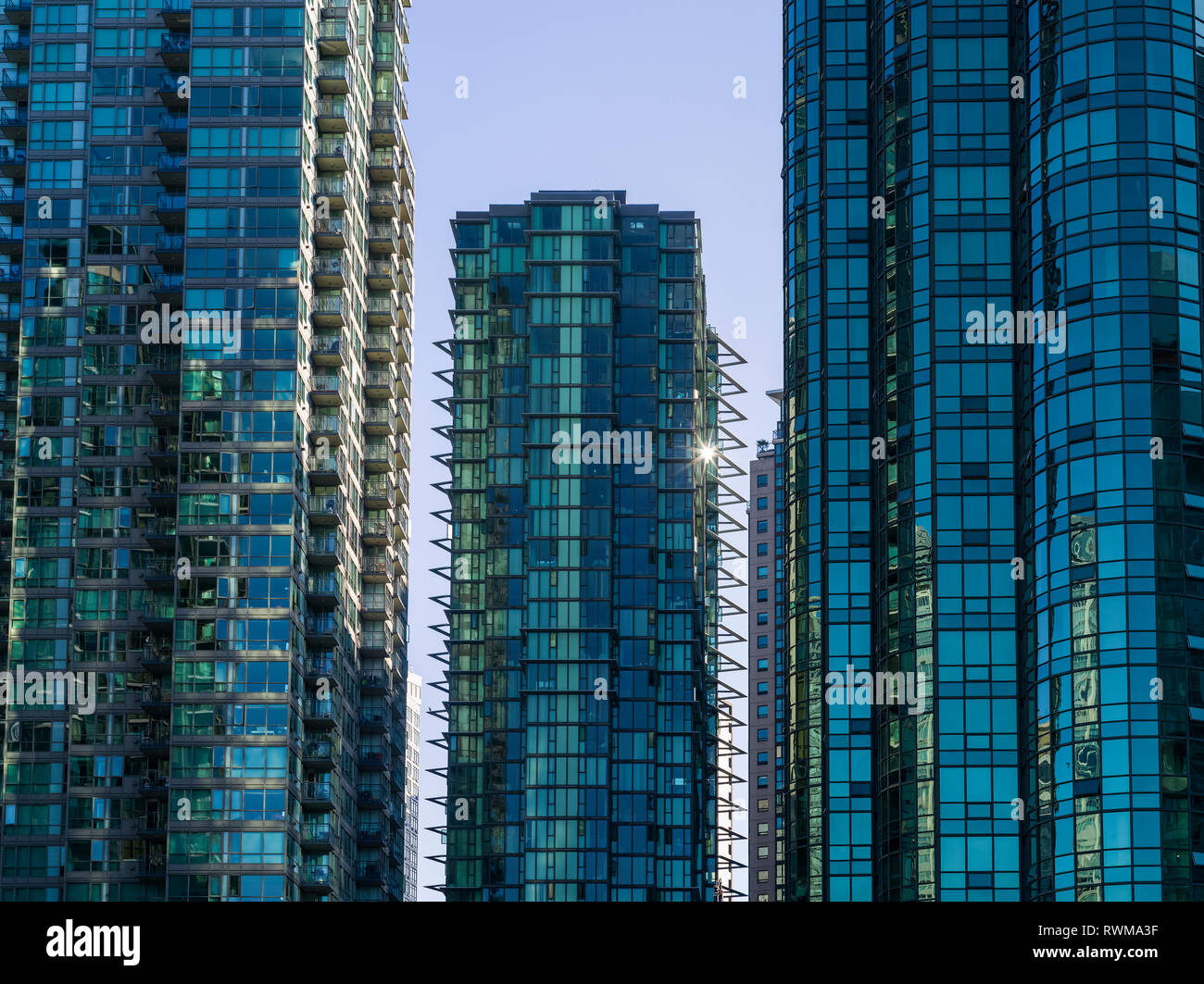Condomini grattacielo con facciata di vetro che riflette il blu del cielo; Vancouver, British Columbia, Canada Foto Stock
