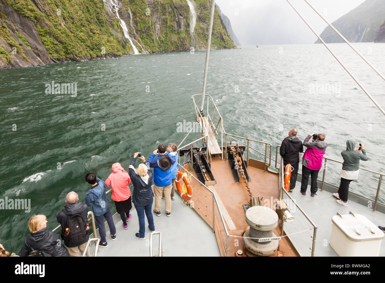 I turisti in una barca a Milford Sound, Nuova Zelanda Foto Stock