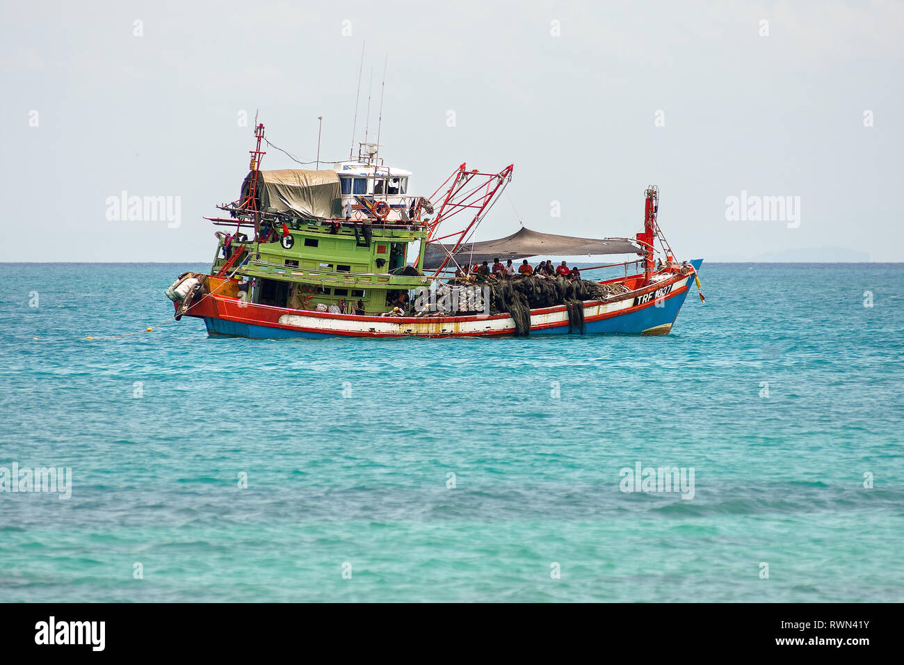 Tradizionale industriale in grande scala la pesca in barca con equipaggio sul ponte in calme acque tropicali. Foto Stock