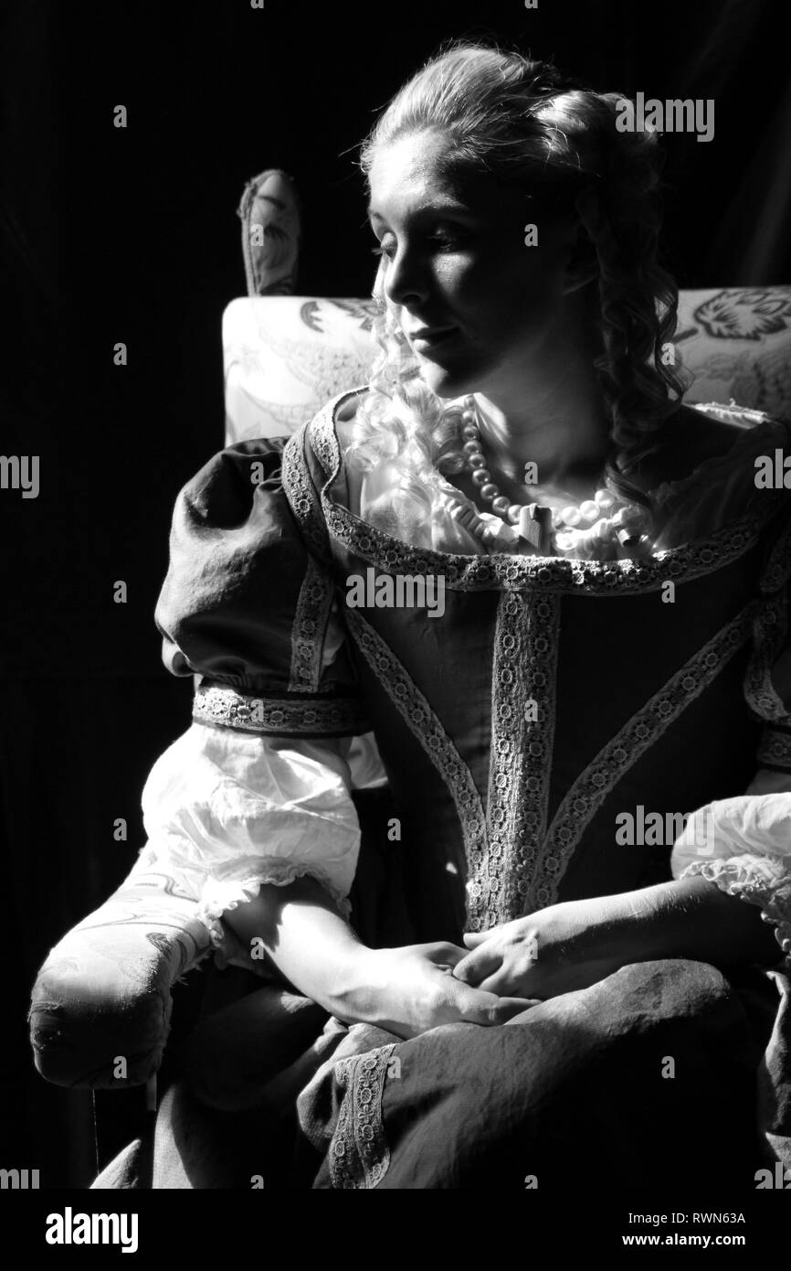 Ritratto di una giovane e bella donna in ornato abito storico- i suoi vestiti sono belle, indossa perle attorno alla sua gola & ha arricciato i capelli biondi. Foto Stock