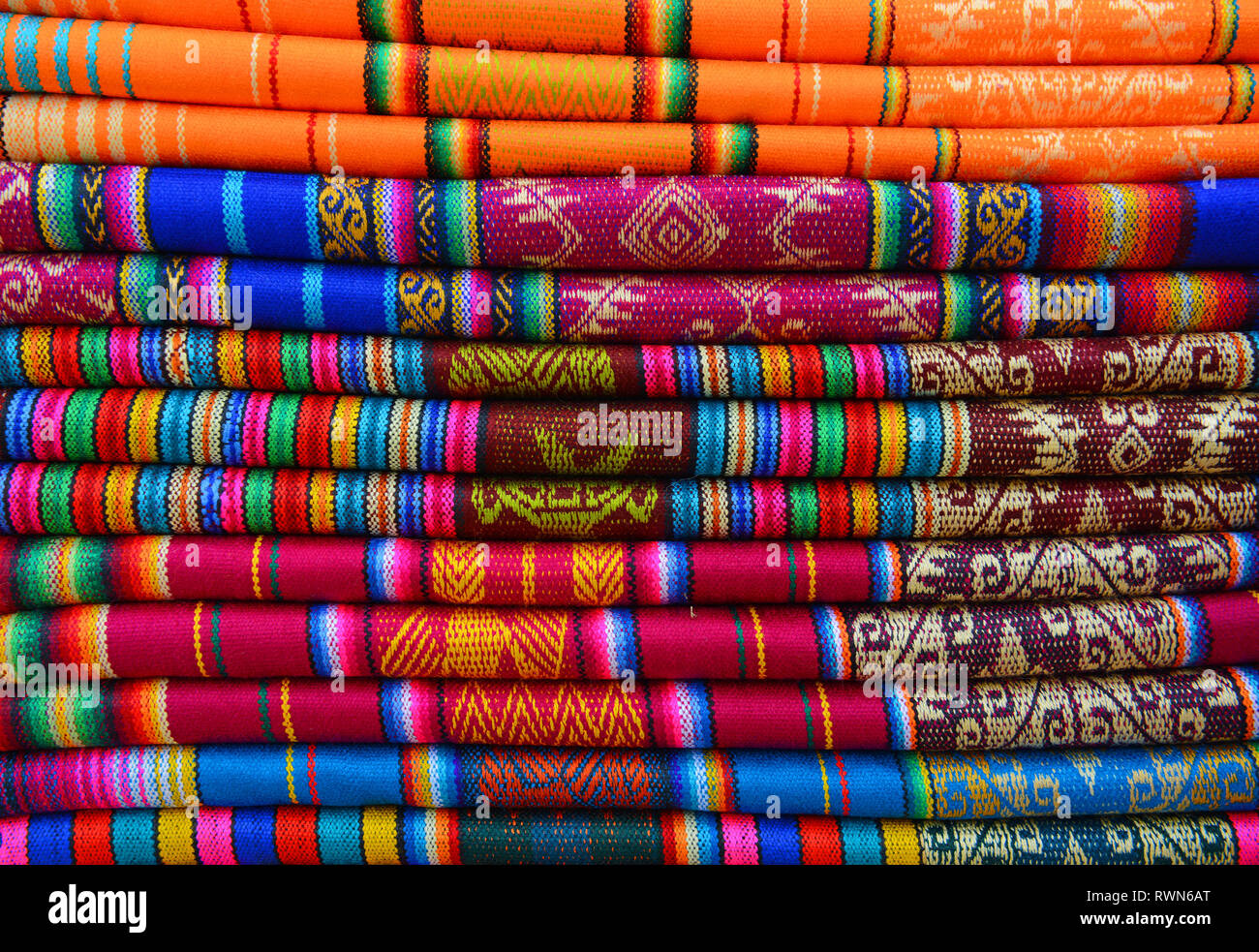 Colorato pila di prodotti tessili sul mercato indigeno di Otavalo, Ecuador. Questi tessuti possono essere trovati nel mondo andino: Perù, Bolivia, Ecuador. Foto Stock