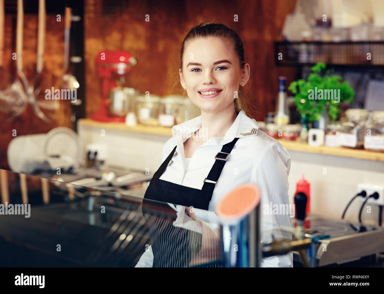 Ritratto di un felice giovane donna che lavora in un negozio di caffè Foto Stock