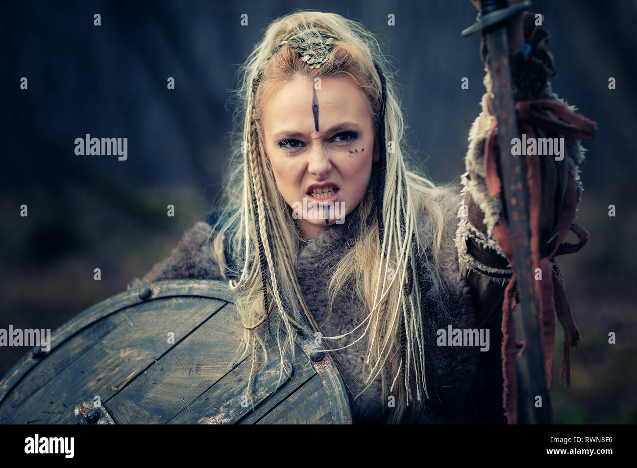 Pazzo furioso viking donna guerriero nell'attacco. Cotica erbosa e di scudo. Close-up verticale. Copertina del libro Foto Stock