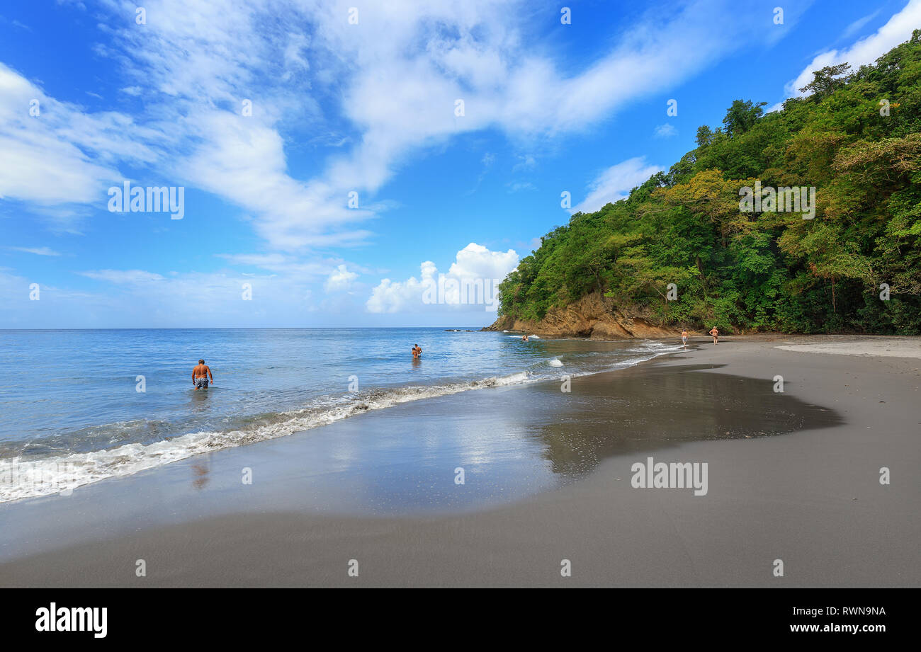 Spiaggia di sabbia nera in Martinica, dei Caraibi. Anse Couleuvre, Le Precheur Regione, vicino Motagne Pelée. Le persone in cerca di acqua per le tartarughe. Foto Stock Spiaggia di sabbia nera in Martinica, dei Caraibi. Anse Couleuvre, Le Precheur Regione, vicino Motagne Pelée. Le persone in cerca di acqua per le tartarughe. Foto Stock